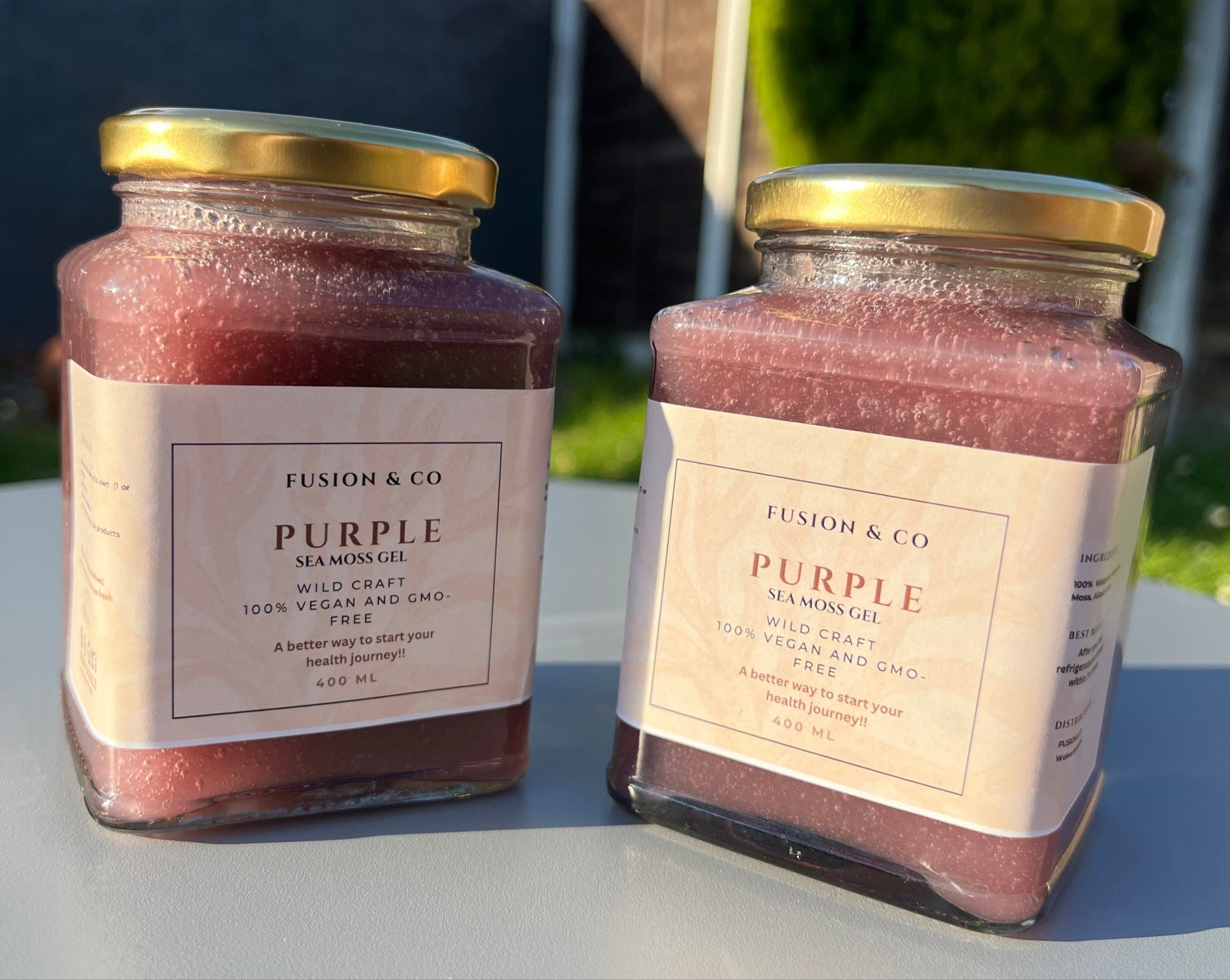 Two jars of 'Purple' sea moss on a garden surface with seaweed.